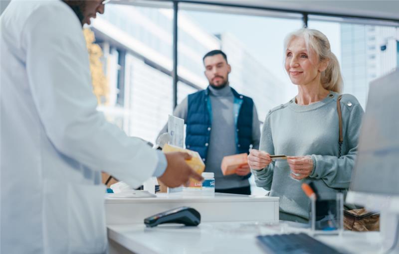pharmacist at register with customers