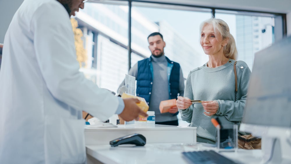 pharmacist at register with customers