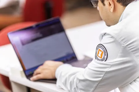UFO student sitting at table on a laptop